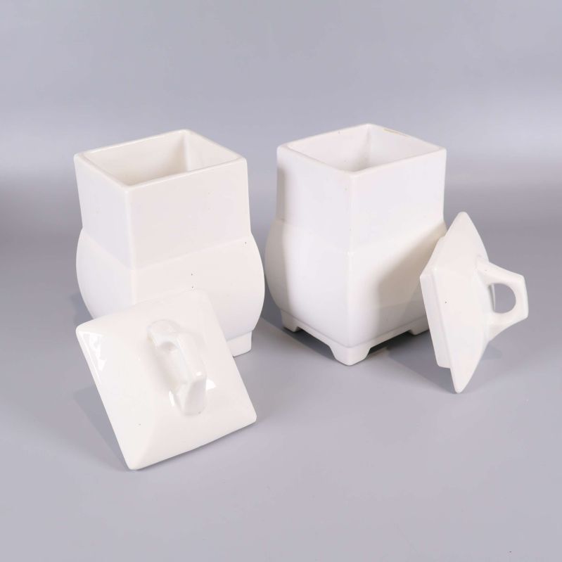 Två vita burkar med avtagna lock visar insidan