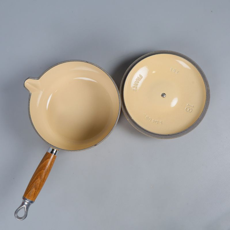 Insidan av gul gjutjärnsgryta och lock visar ljus yta