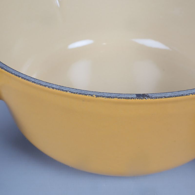 Närbild på kant med slitage på gul gryta