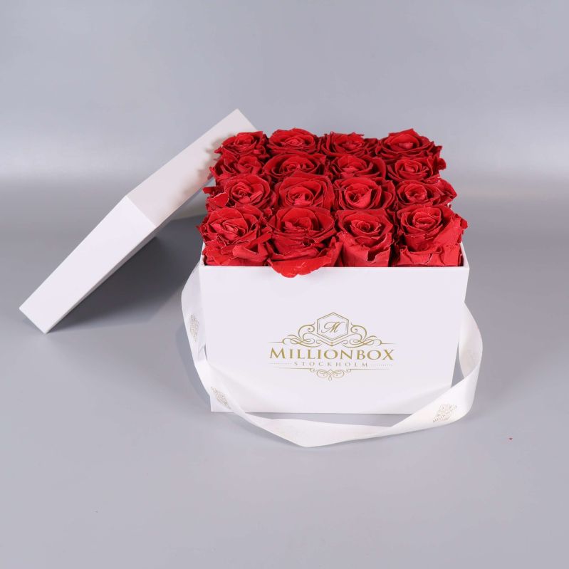 Vit kvadratisk box med röda rosor och öppet lock