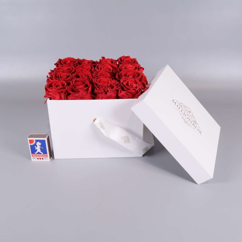 Rosbox med röda rosor och tändsticksask för storleksjämförelse