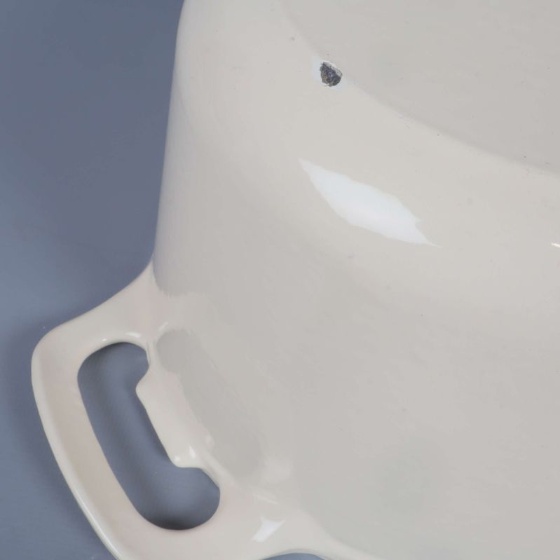 Närbild på grytans botten med liten skada i emaljen