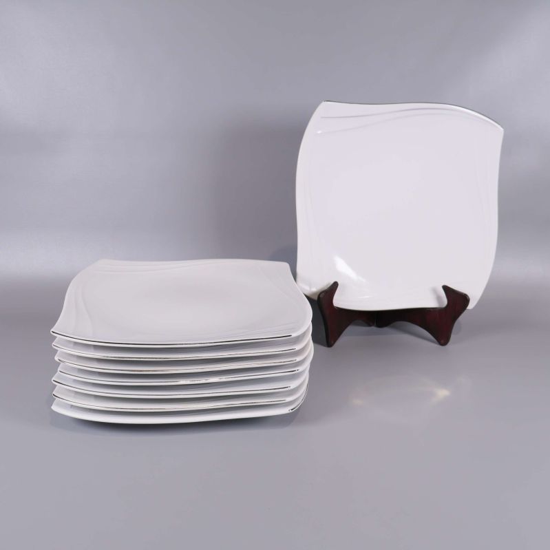 Åtta staplade vita fyrkantiga tallrikar, en styck visas på ställ