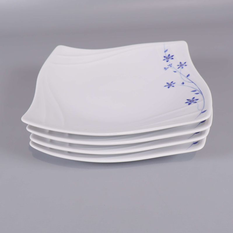 Fyra staplade vita assietter med blått motiv