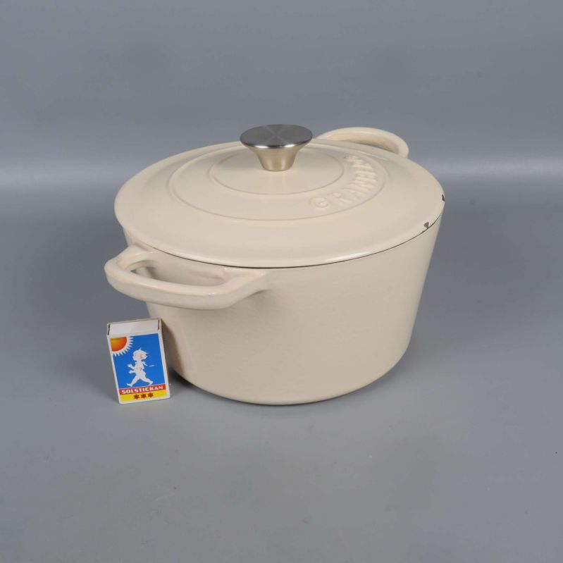 Gryta från sidan med tändsticksask för storleksreferens