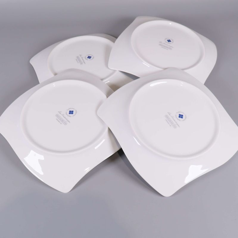 Fyra assietter vända med baksidan upp, designstämpel synlig