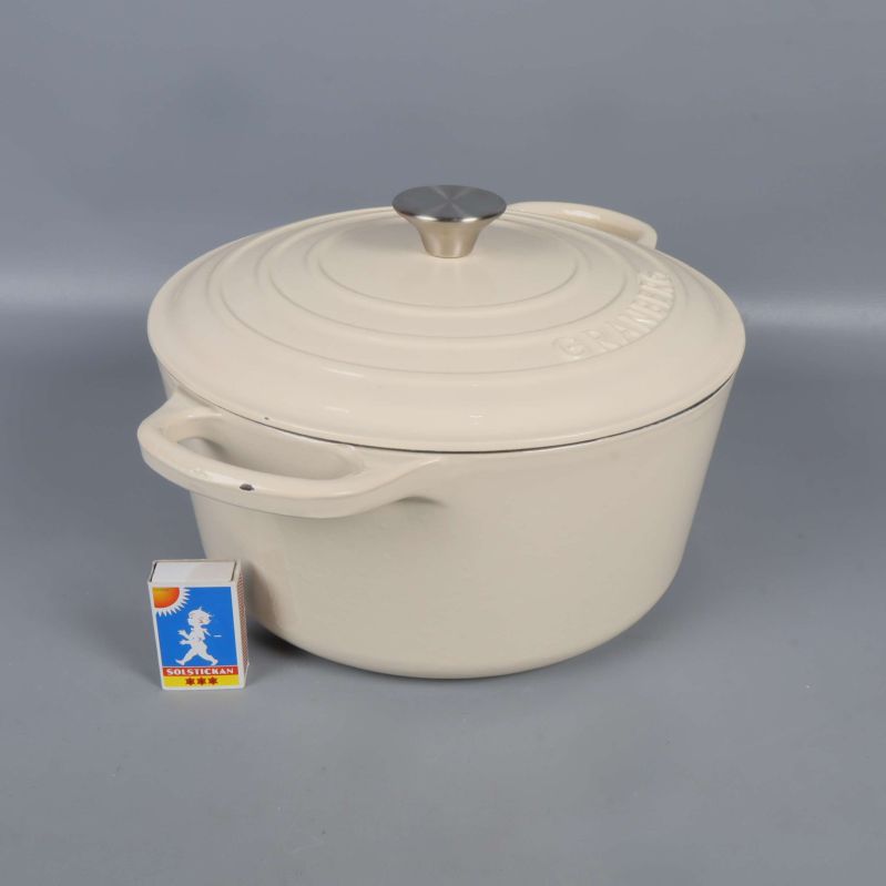 Gryta med lock bredvid tändsticksask för storleksjämförelse