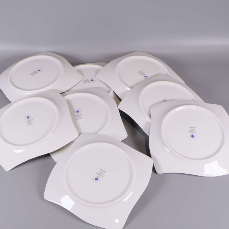 Baksidan av samtliga åtta vita assietter