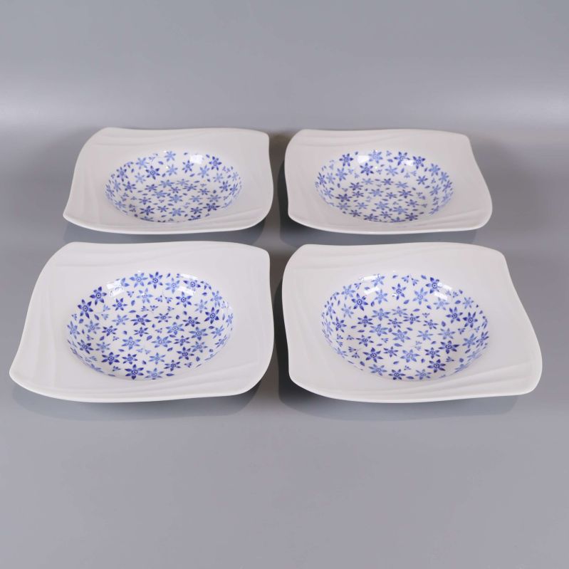 Fyra blommiga djupa tallrikar arrangerade på rad