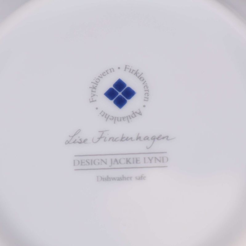 Närbild på märkning Fyrklövern och Jackie Lynd under tallrik