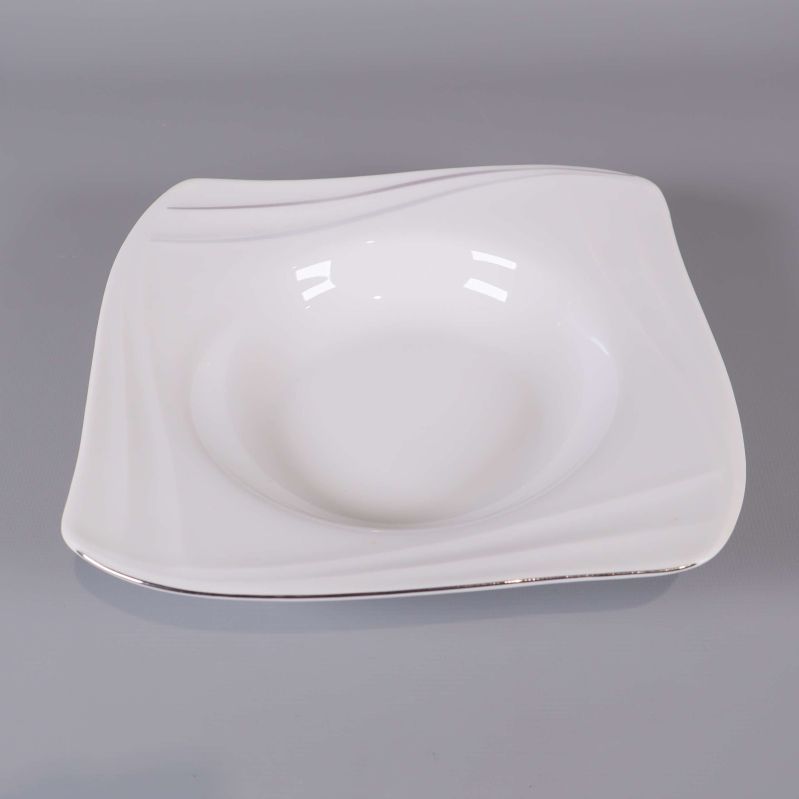 En ensam vit fyrkantig djup tallrik uppifrån