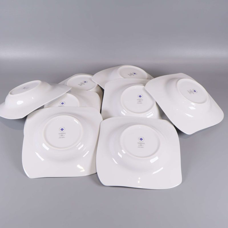 Åtta vita fyrkantiga tallrikar vända upp och ner