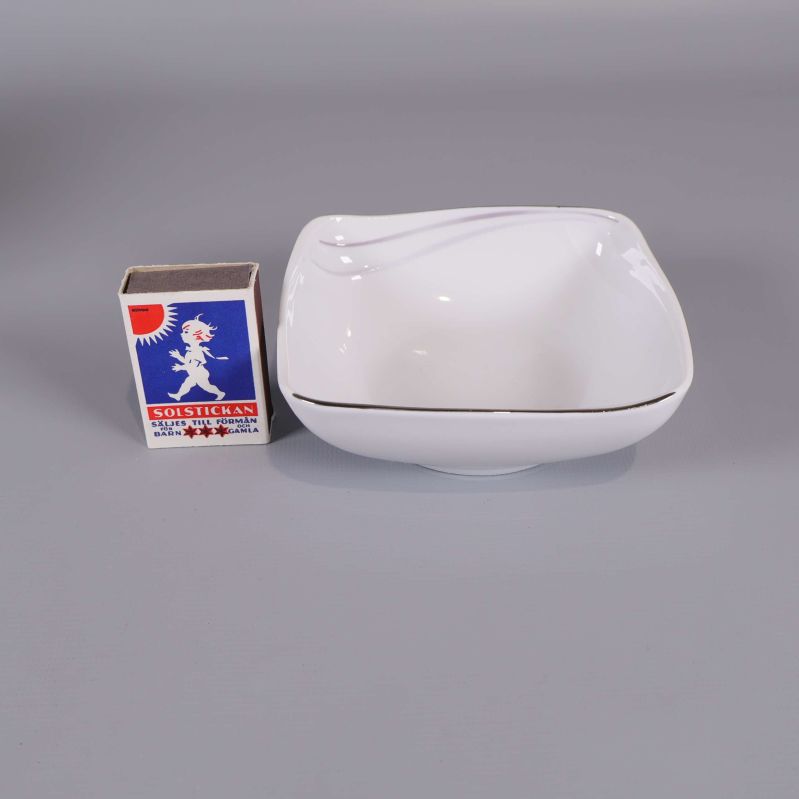 Vit fyrkantig skål bredvid tändsticksask