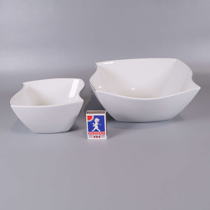 Två vita skålar bredvid tändsticksask för storleksjämförelse