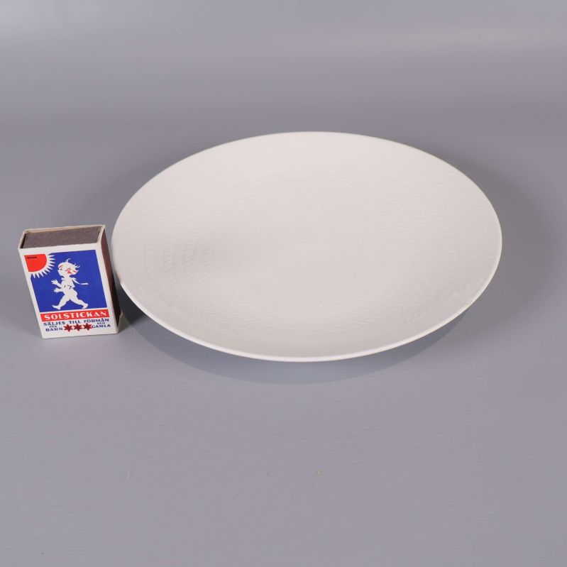 En vit assiett bredvid en tändsticksask visas uppifrån