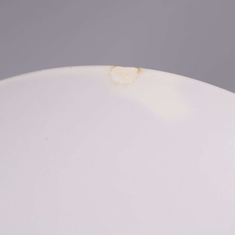 Närbild på nagg i kanten på vit assiett