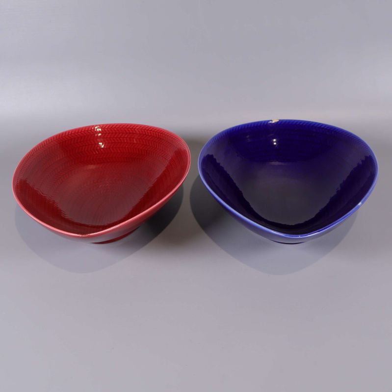 Två mönstrade skålar, en röd och en blå, bredvid varandra