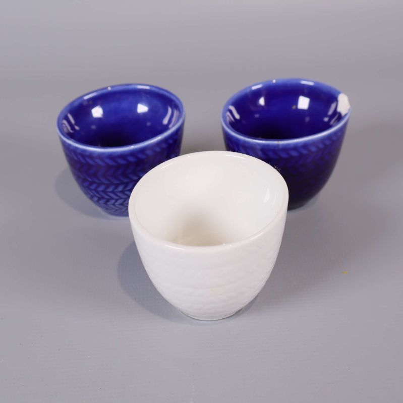 Tre äggkoppar i porslin, två blå och en vit