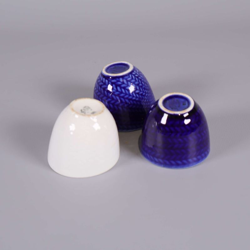 Tre äggkoppar med undersidan synlig på vit kopp