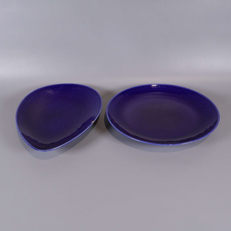 Två blå serveringsfat i rundad och oval form