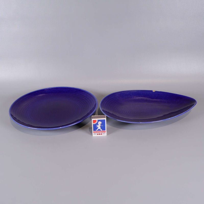 Två blå serveringsfat bredvid en tändsticksask för storleksjämförelse