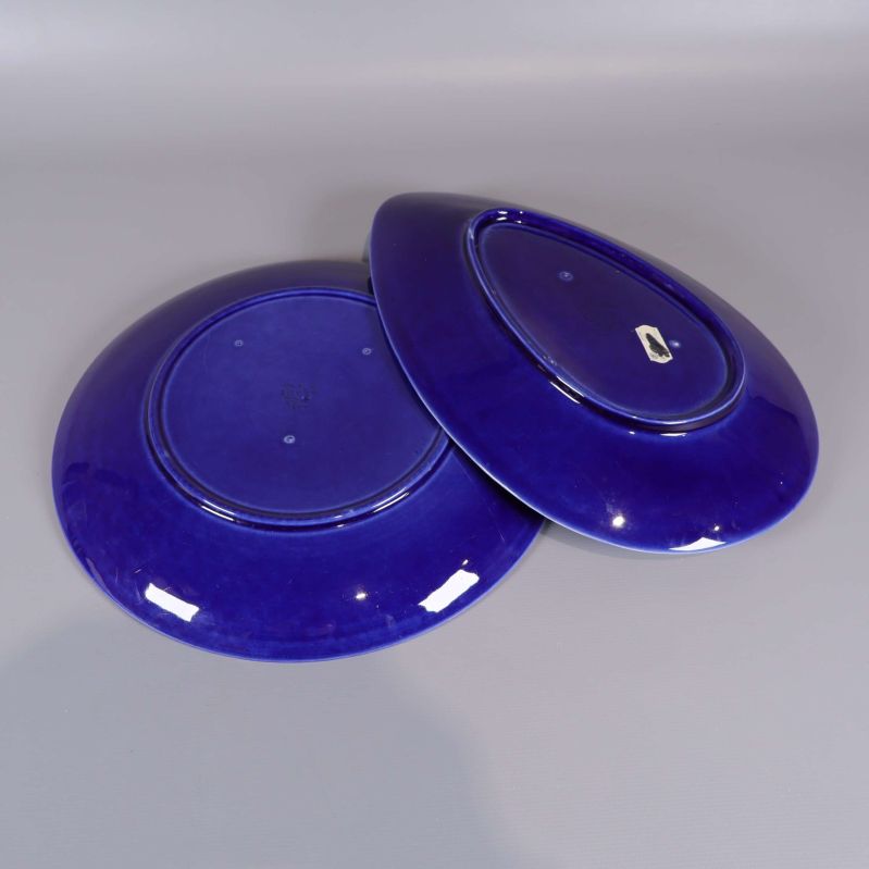 Undersidan av två blå serveringsfat