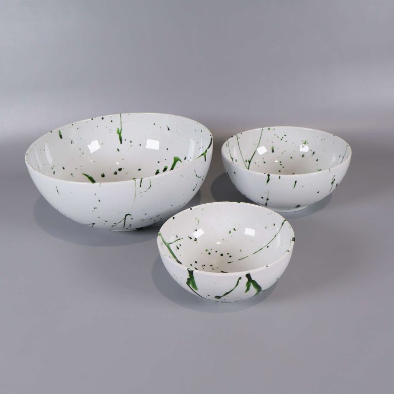 Tre vita skålar med grönt splashmönster på rad