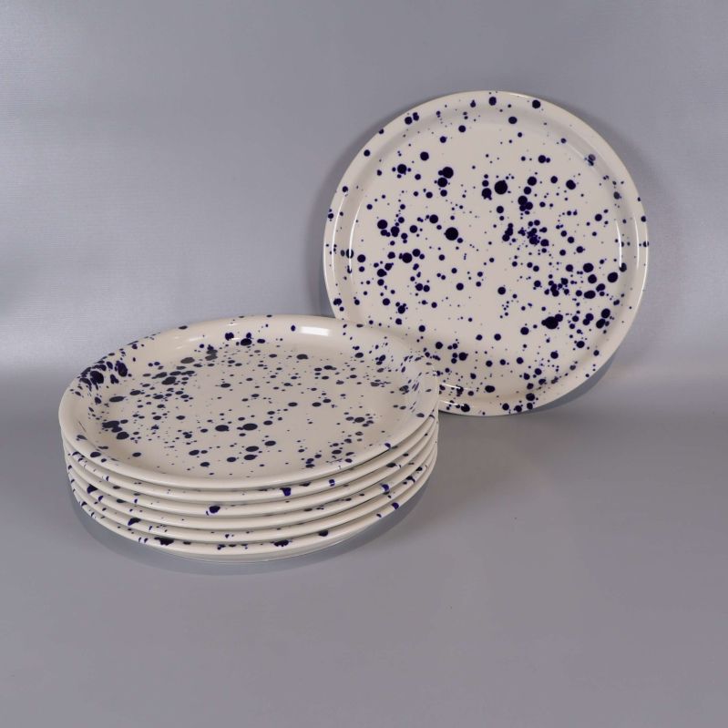 Sex tallrikar staplade och en stående med blå stänk