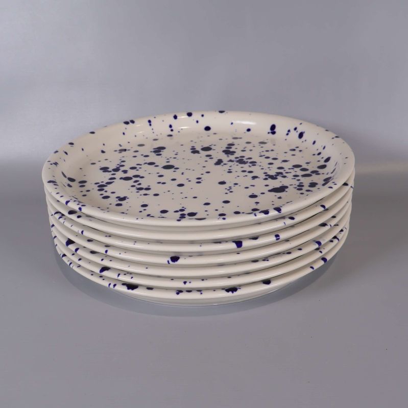 Närbild på sex staplade tallrikar med blå stänk