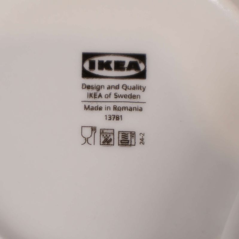 Närbild på IKEAs logotyp och märkning under tallrik