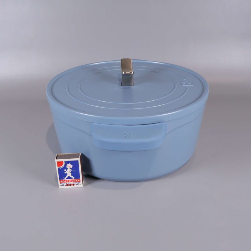 Blå gryta med lock bredvid tändsticksask för storleksjämförelse