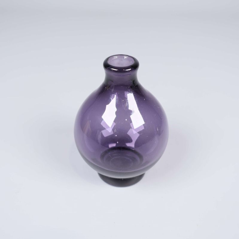 Lila glasvas med rund form visas framifrån