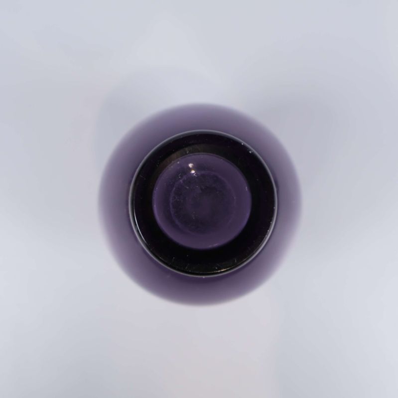 Botten på den lila glasvasen visas uppifrån