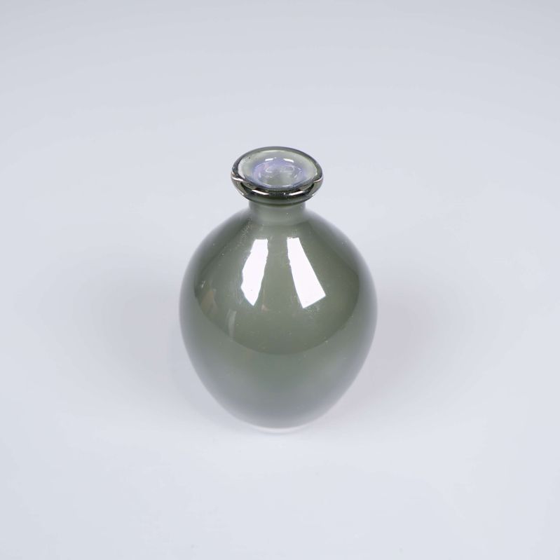 Grågrön glasvas med smal hals och rund kropp visas snett ovanifrån