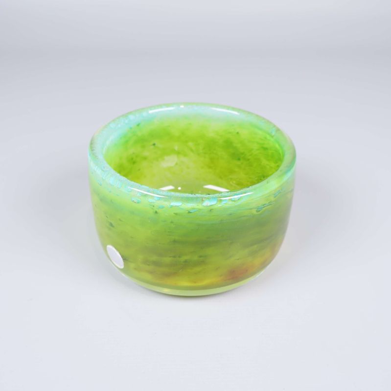 Grön skål i handblåst glas sedd snett ovanifrån