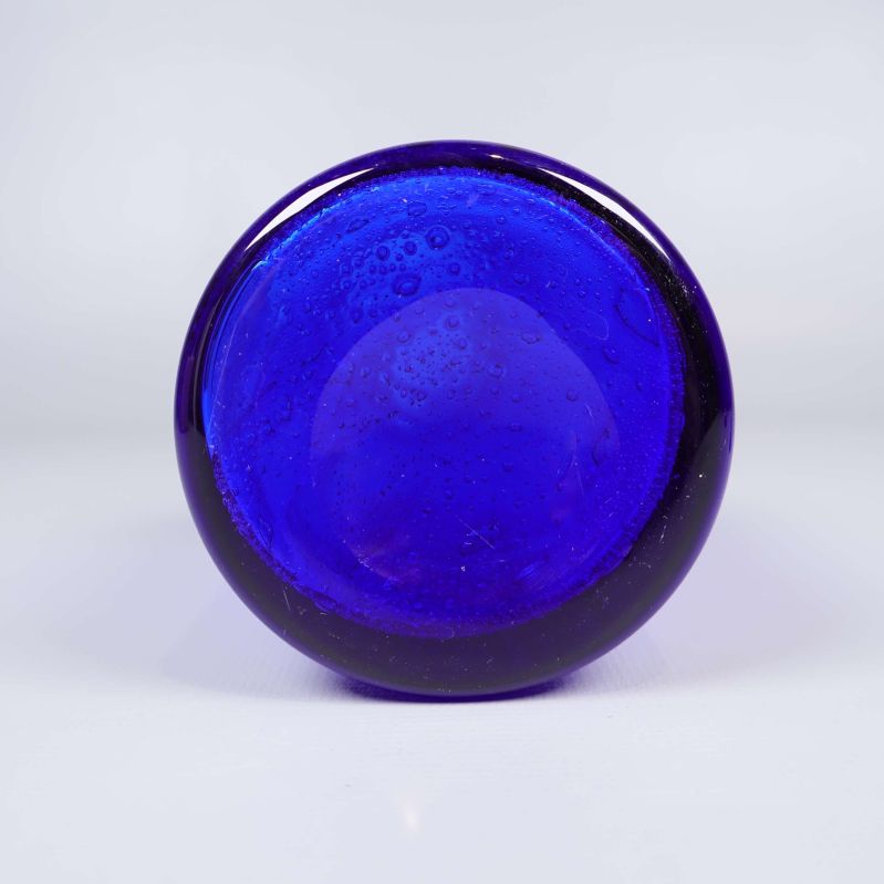 Undersidan av blå glasflaska med synliga luftbubblor