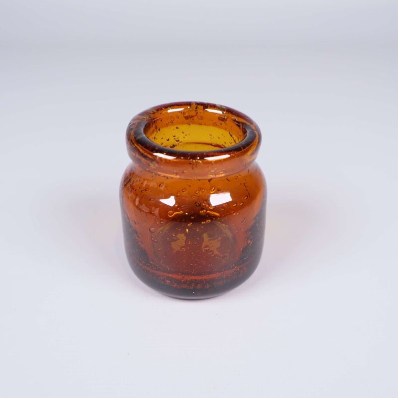 Liten bärnstensfärgad glasvas med bubblor fotograferad framifrån