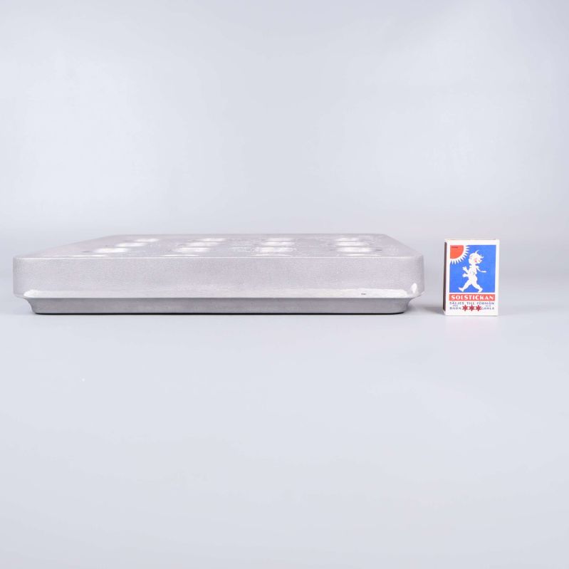 Sidovy av ljusstake bredvid tändsticksask som storleksreferens