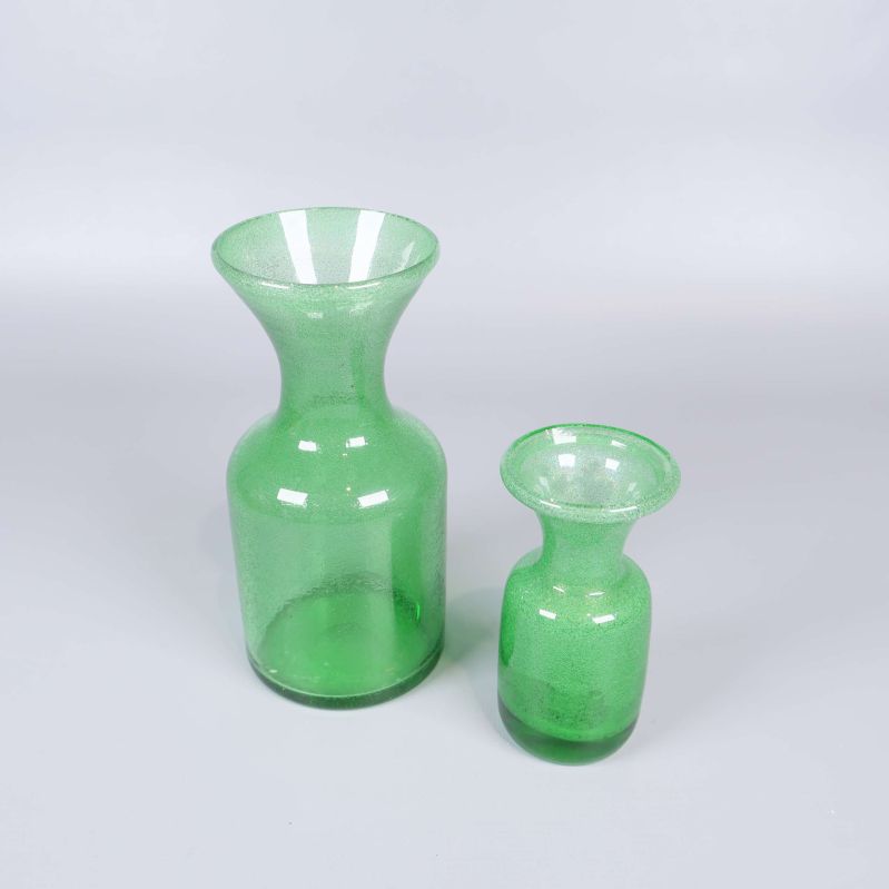 Två gröna glasvaser med bubblig yta mot ljus bakgrund