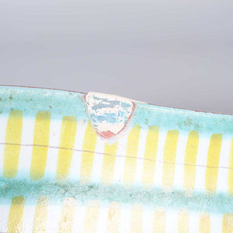 Närbild av emblem vid skålens kant med sliten text