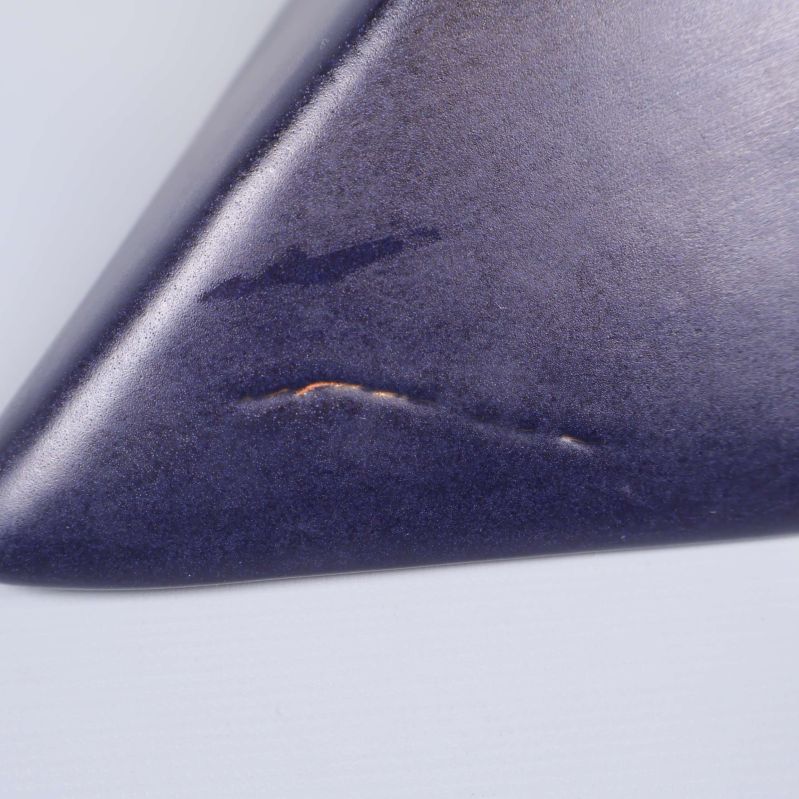 Närbild på slitage eller repa längst ner på fatets hörn