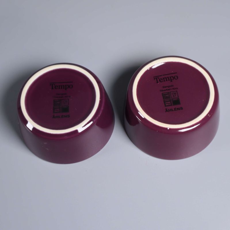 Undersida av två lila skålar med Tempo och Åhléns logga