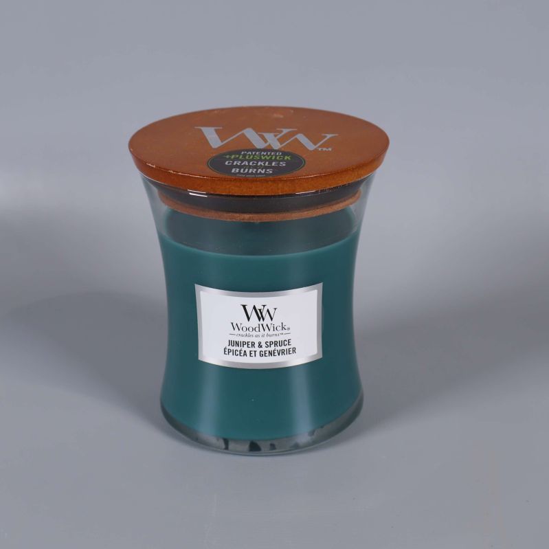 Doftljus med grönt vax och trälock på grå bakgrund