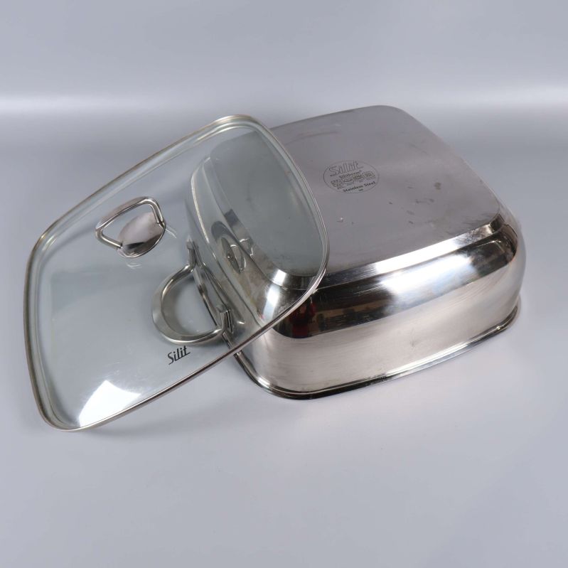 Glaslock och gryta i rostfritt stål i närbild