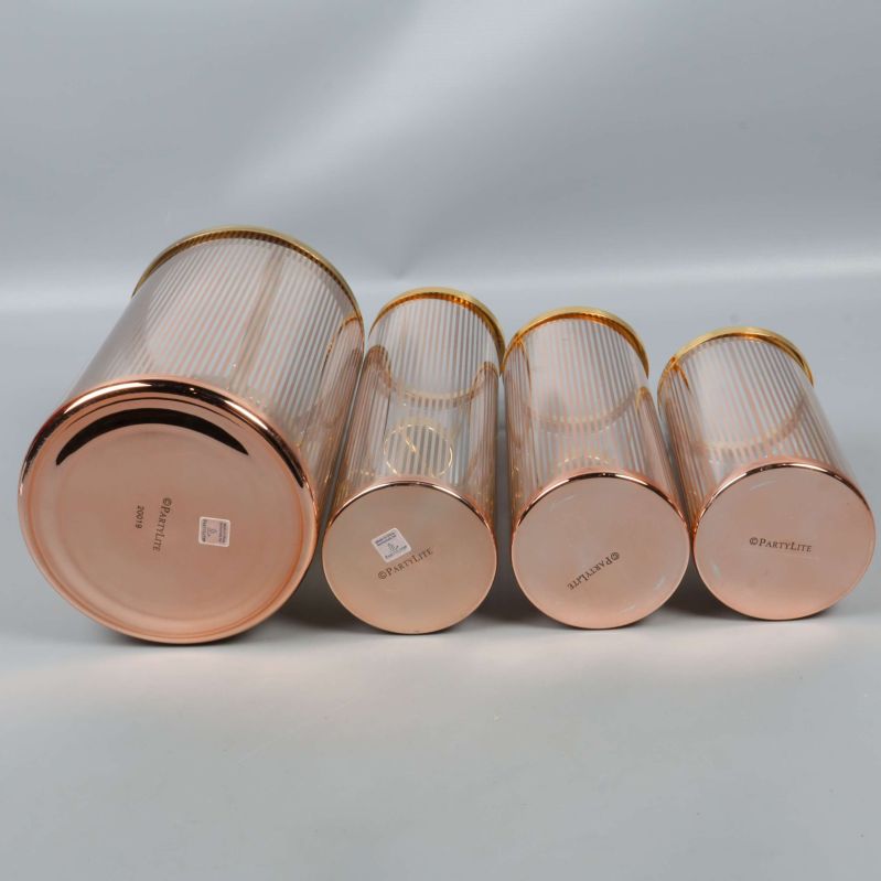 Fyra ljuslyktor liggande med botten uppåt och etiketter synliga