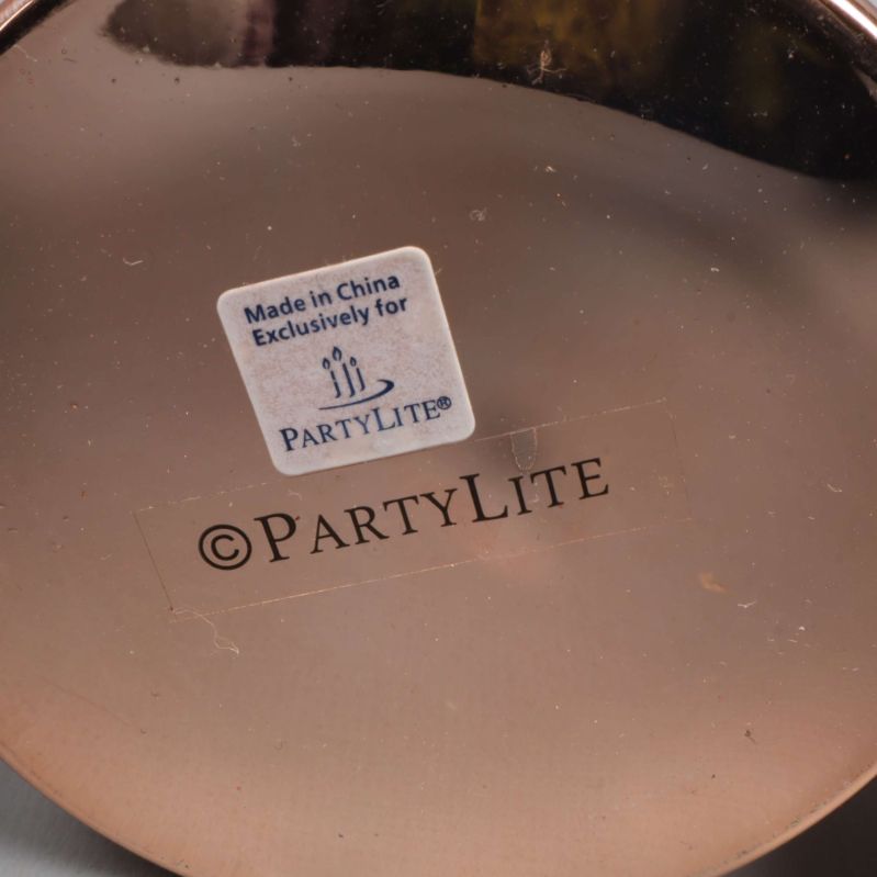 Närbild på botten av ljuslykta med Partylite-logotyp