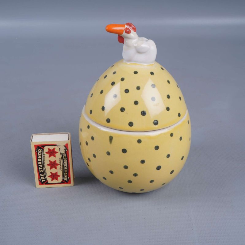 Äggformad burk med tändsticksask som storleksreferens