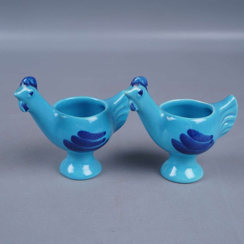 Framifrån vy av två blå fågelformade äggkoppar