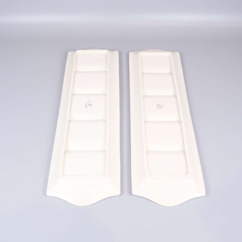 Baksidan av två rektangulära vita fat visas