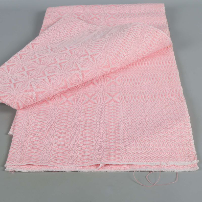 Det ljusrosa tyget delvis vikt och öppnat för att visa struktur